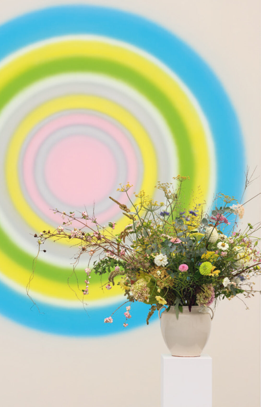 Fotografie einer Blume vor einem Kunstwerk