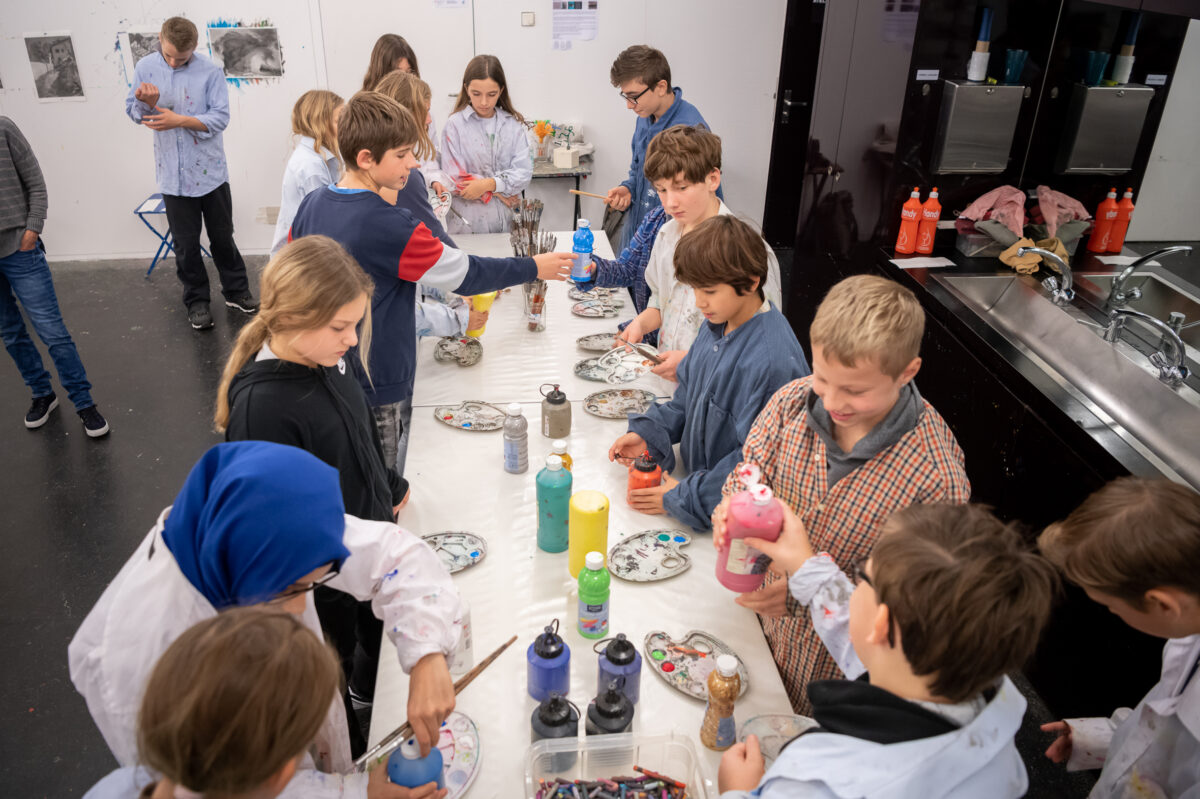 Kinder malen an einem Tisch im Atelier des Aargauer Kunsthauses