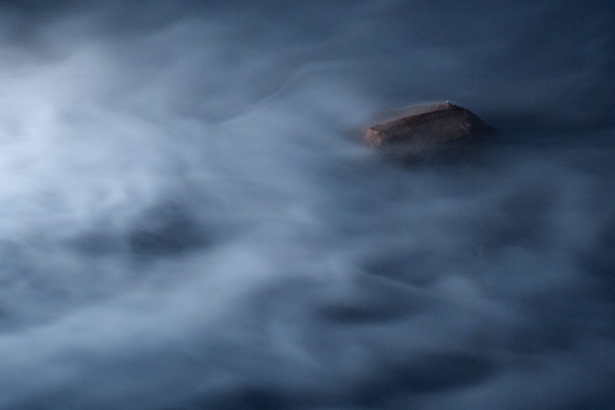 Ein Fels taucht aus einem Nebelmeer auf