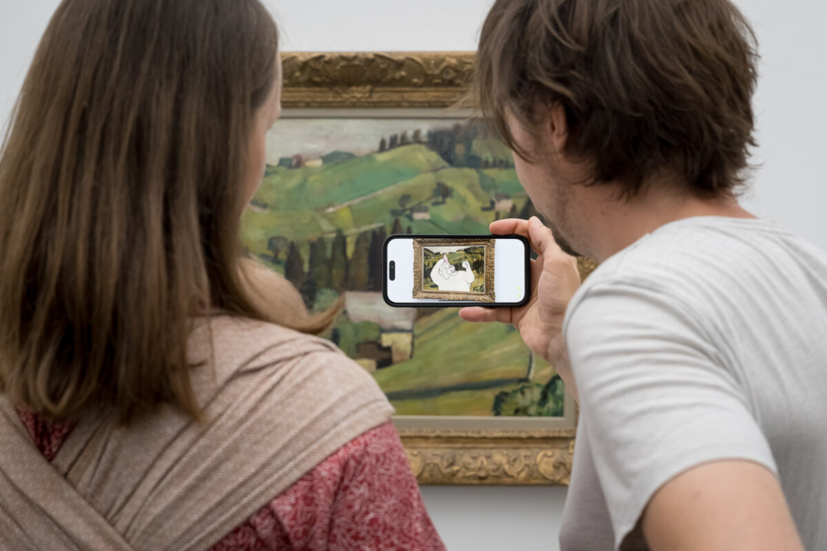 Zwei Personen schauen sich im Aargauer Kunsthaus animierte Kunst mit einem Smartphone an.