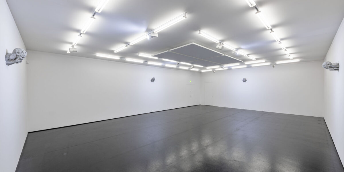 Eine Installationsansicht eines Raumes mit vier Figuren an den Wänden