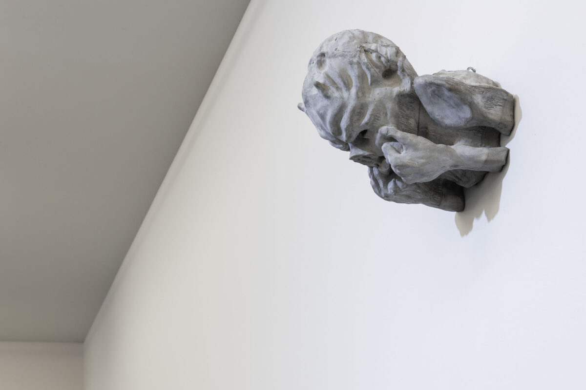 Eine Skulptur, die sich die Hände ins Gesicht hält.