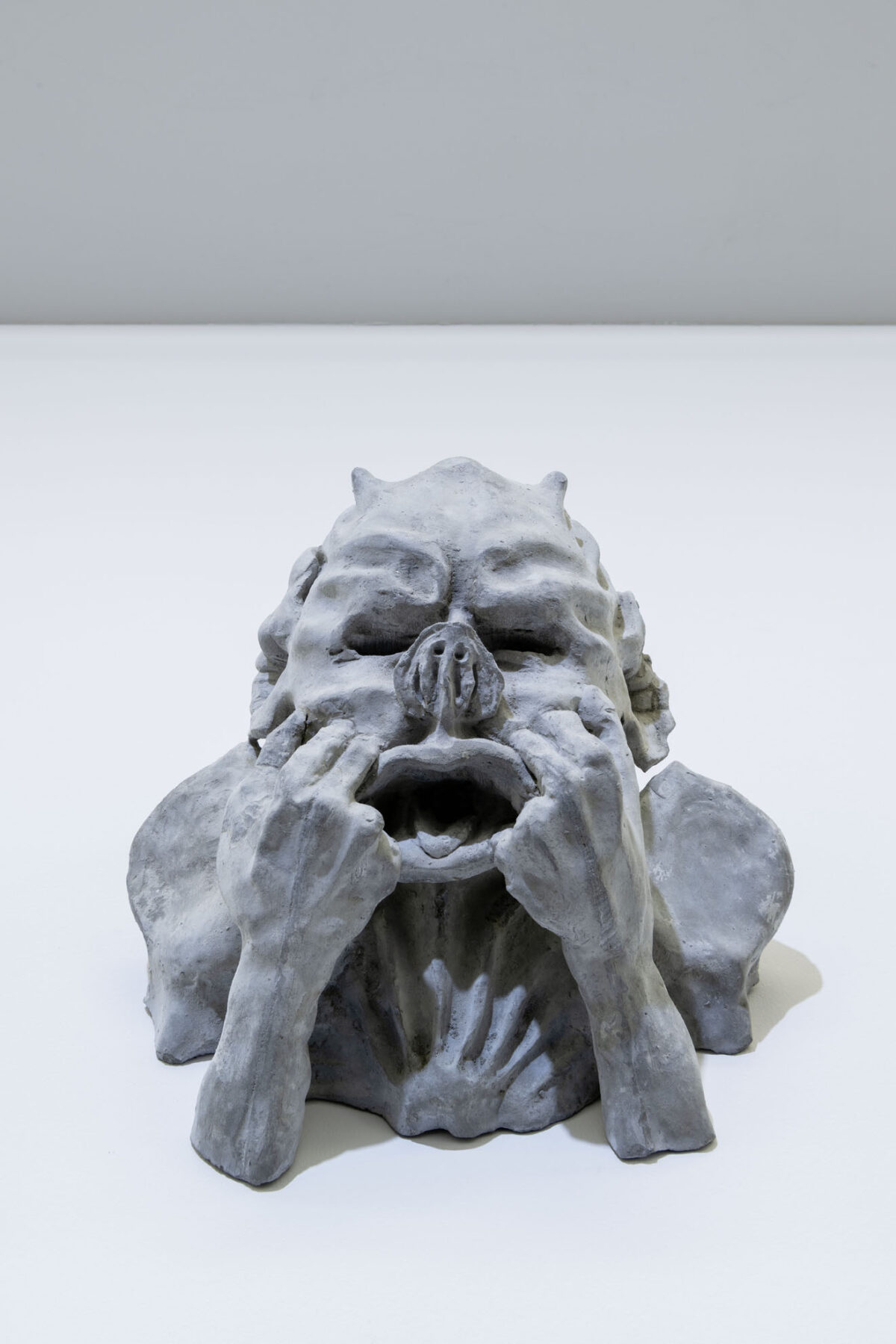 Eine Skulptur, die sich die Hände ins Gesicht hält.