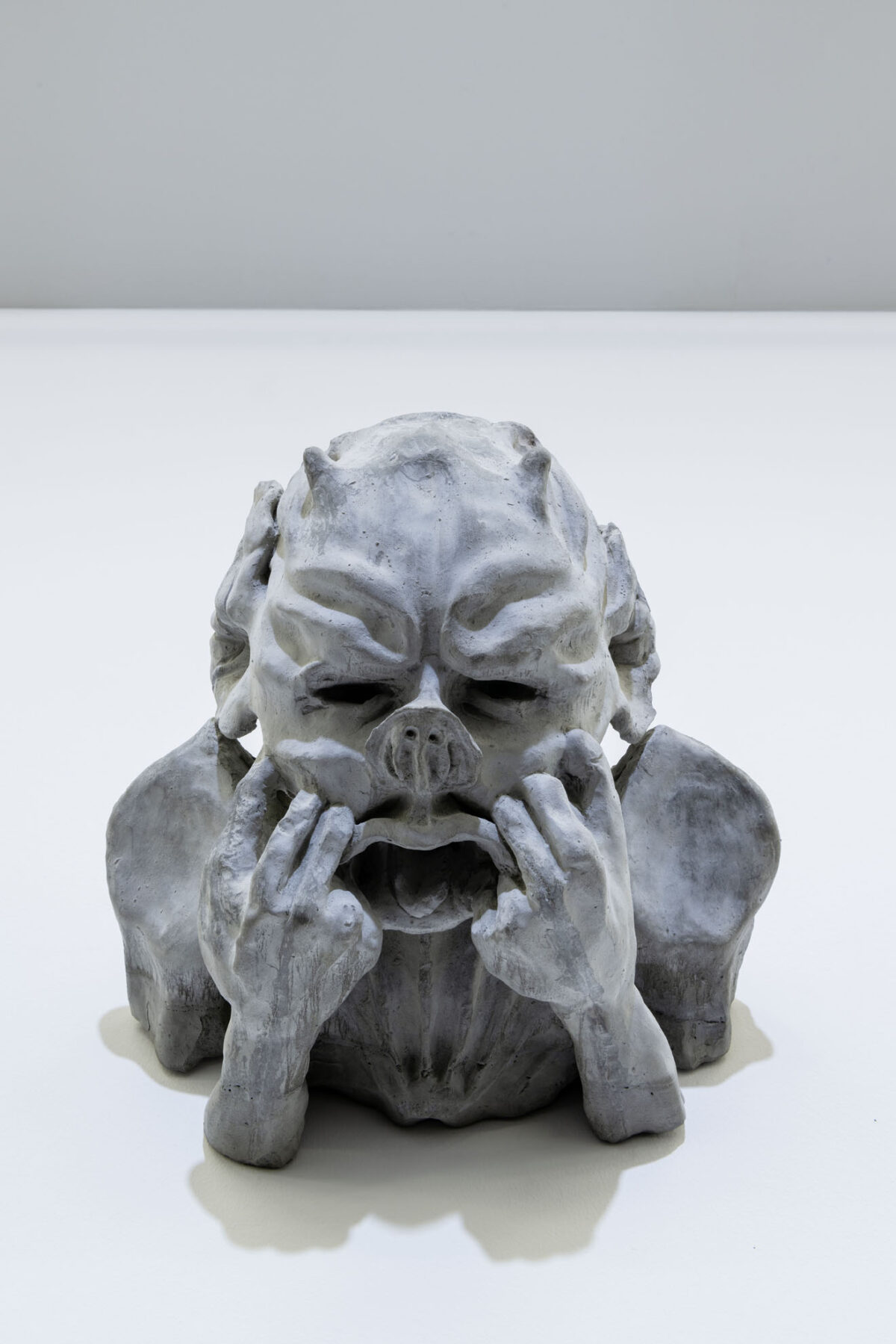 Eine Skulptur, die sich die Hände ins Gesicht hält.