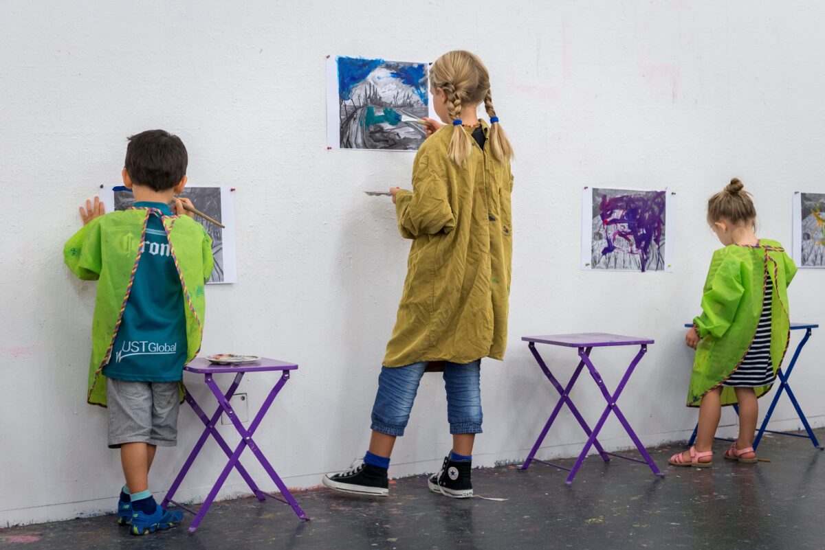 Drei Kinder malen an einer Wand im Atelier des Aargauer Kunsthauses