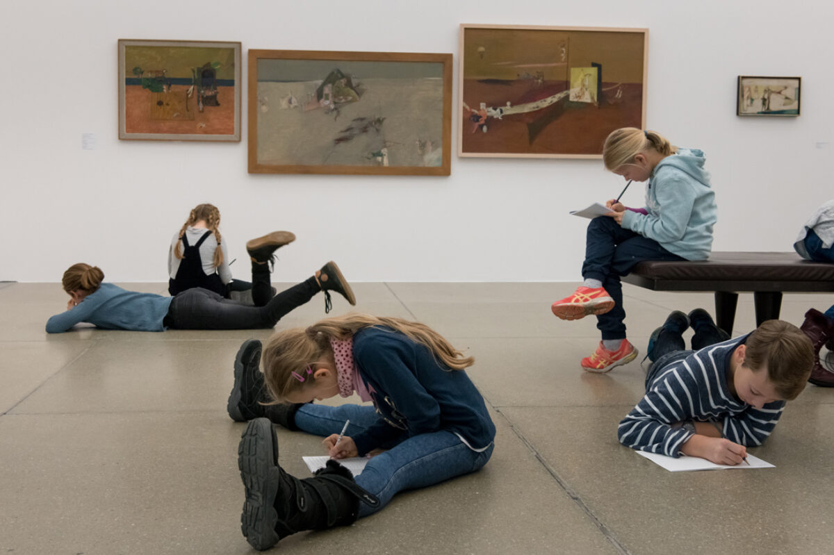 Kinder machen Notizen und zeichnen in einem Ausstellungsraum