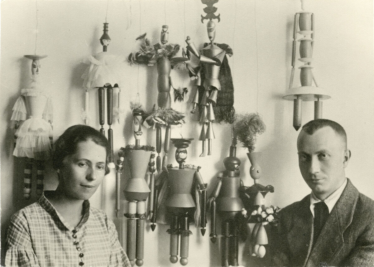 Foto einer Frau und eines Mannes vor Puppen