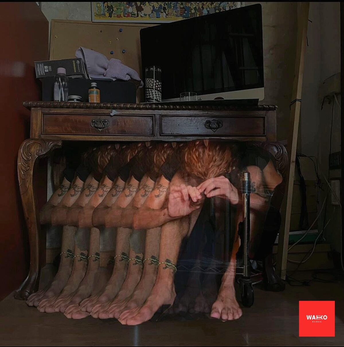 Ein Mensch sitzt unter einem Tisch und multipliziert sich perspektivisch nach hinten.