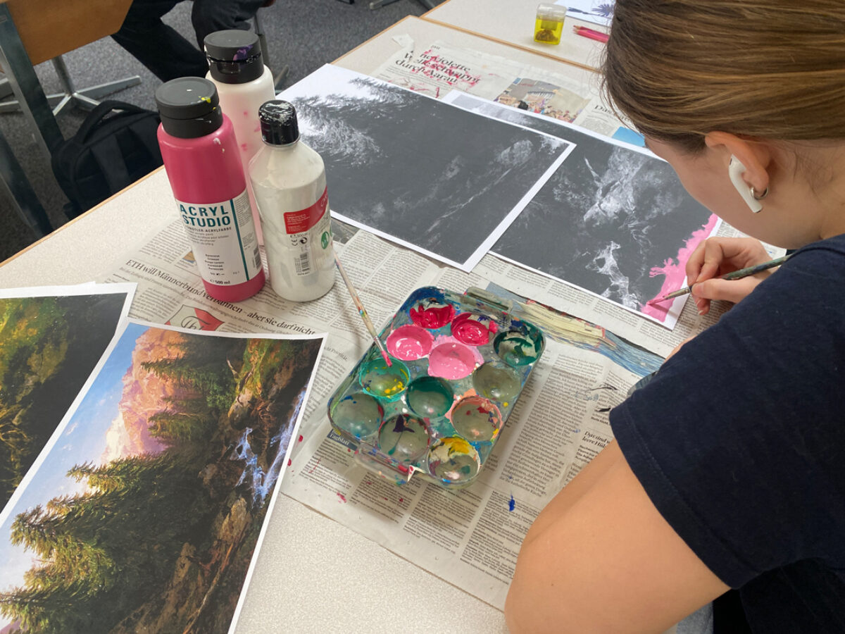 Ein Mädchen übermalt eine Kopie eines Landschaftsgemäldes