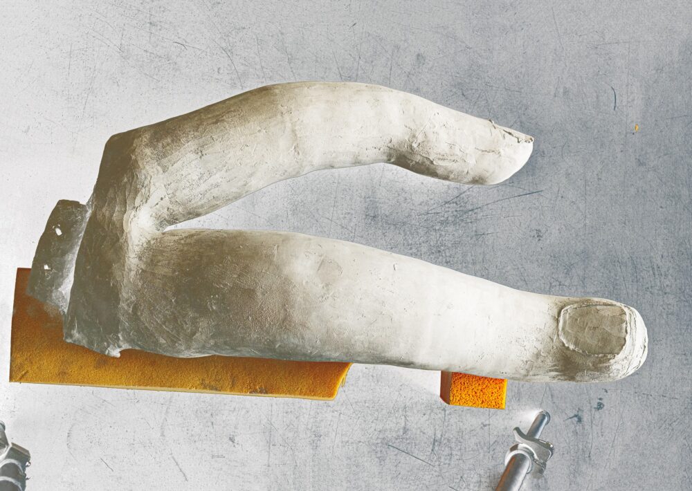 Foto einer Skulptur, die zwei Finger mit prägnantem Fingernagel zeigt.