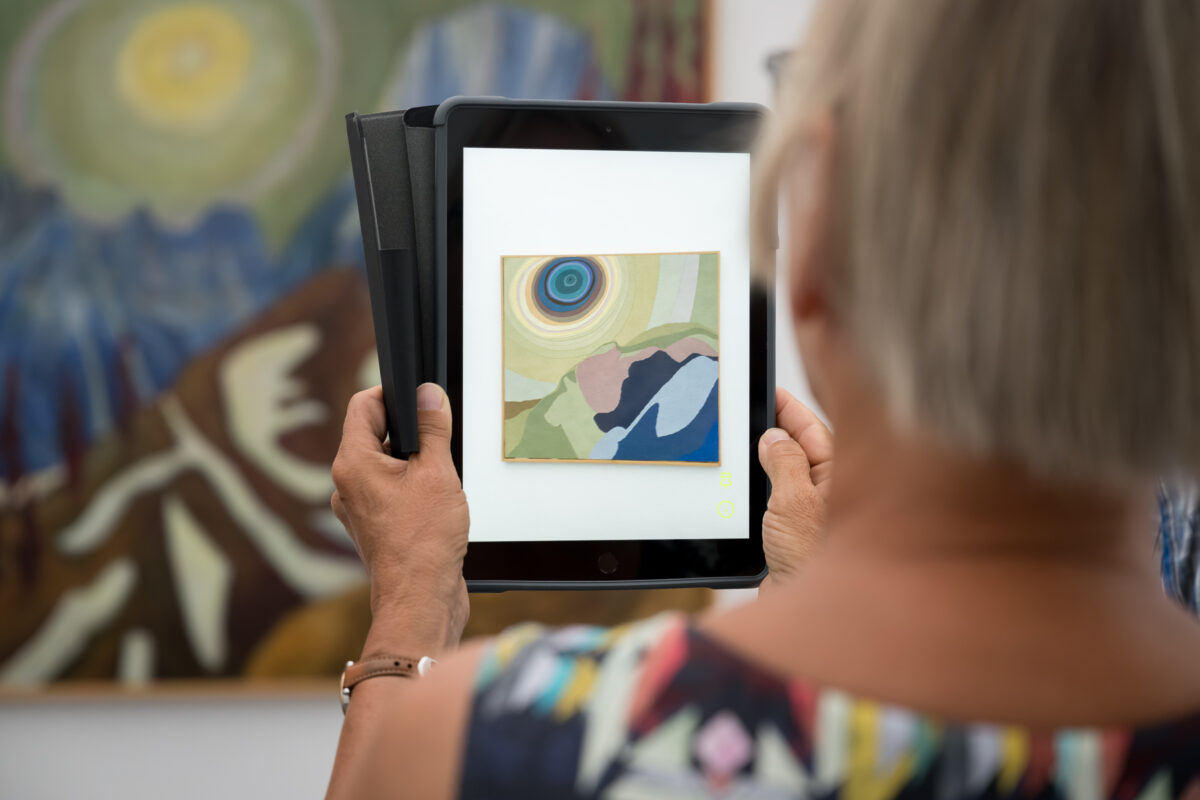 Personen schauen sich mit Tablets animierte Kunst an.