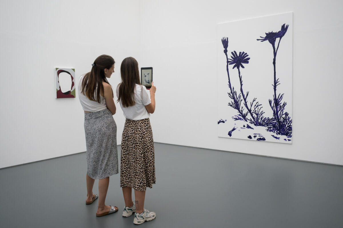 Personen schauen sich mit Tablets animierte Kunst an.