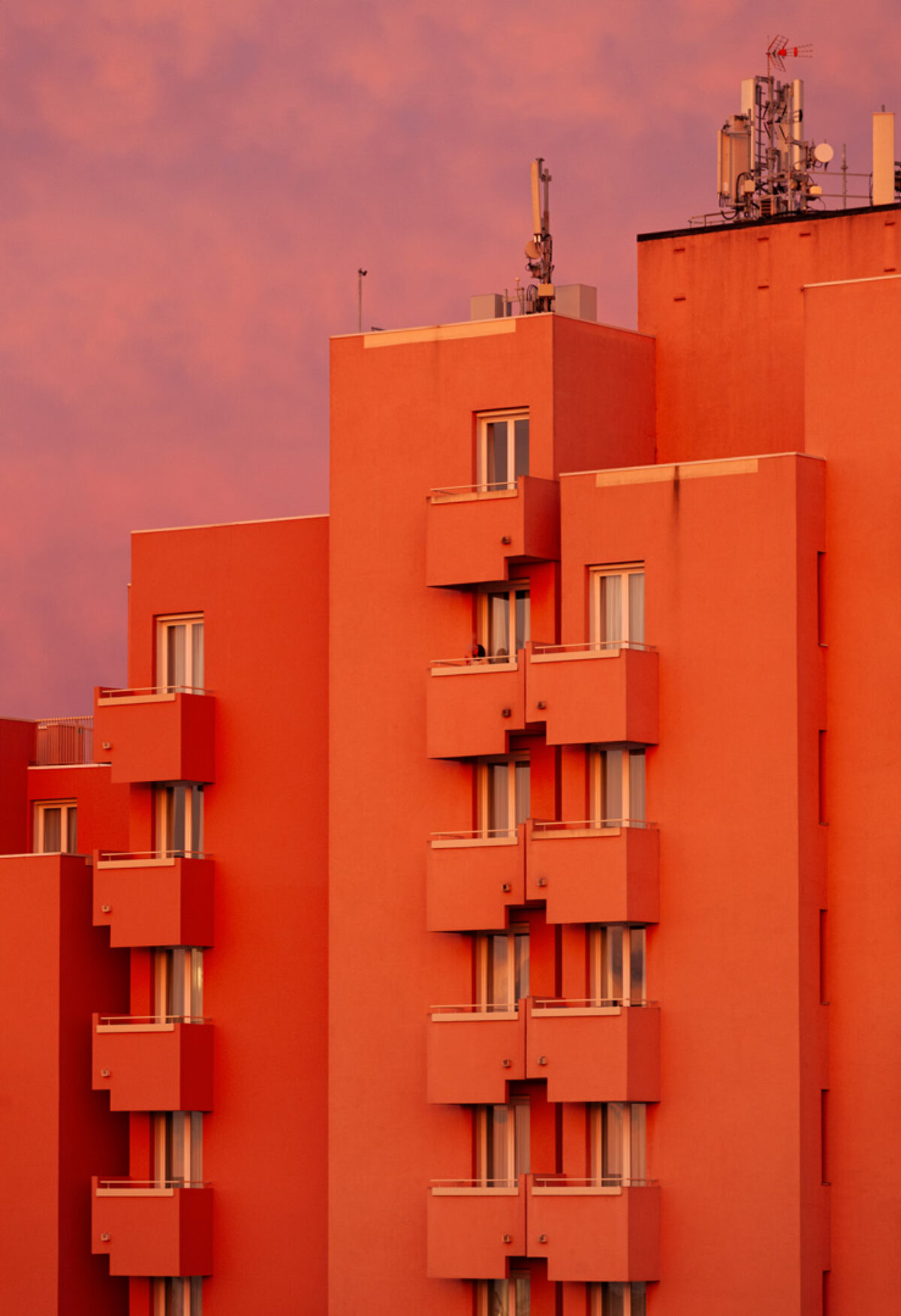 Eine Fotografie eines Häuserblocks mit Balkonen und Antennen auf dem Dach