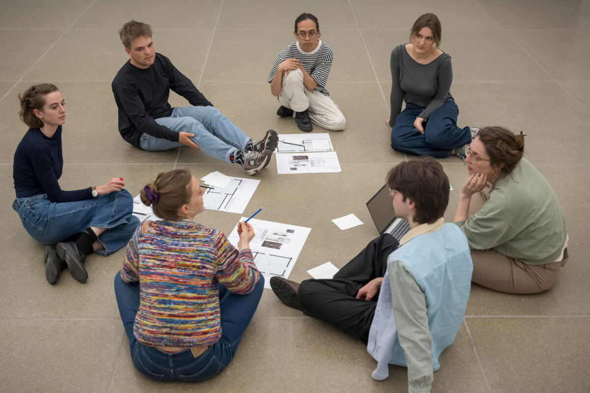 Die Mitglieder NOF4 collective sitzen am Boden und diskutieren