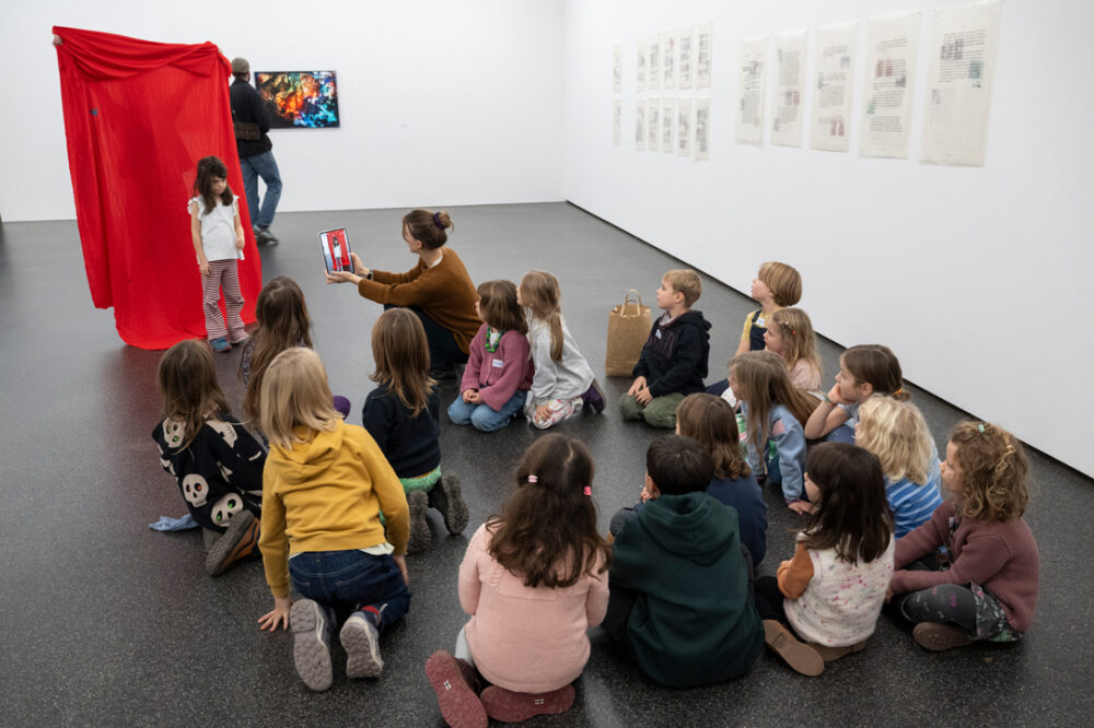 Kinder betrachten ein Kunstwerk an der Kindervernissage.