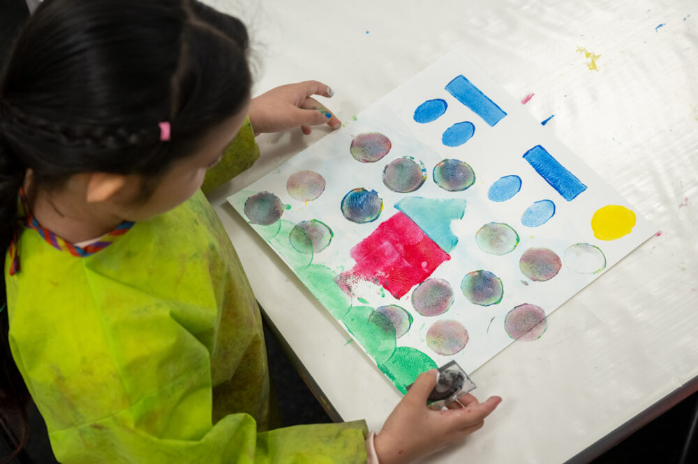 Ein Kind malt ein Bild im Atelier.