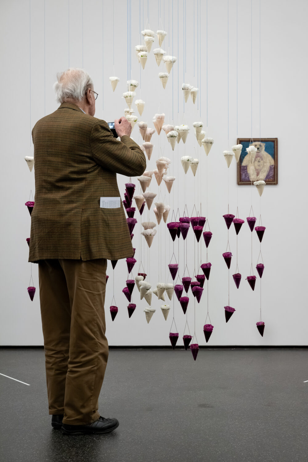 Foto von Personen, die vor einer Blumen für die Kunst Installation stehen