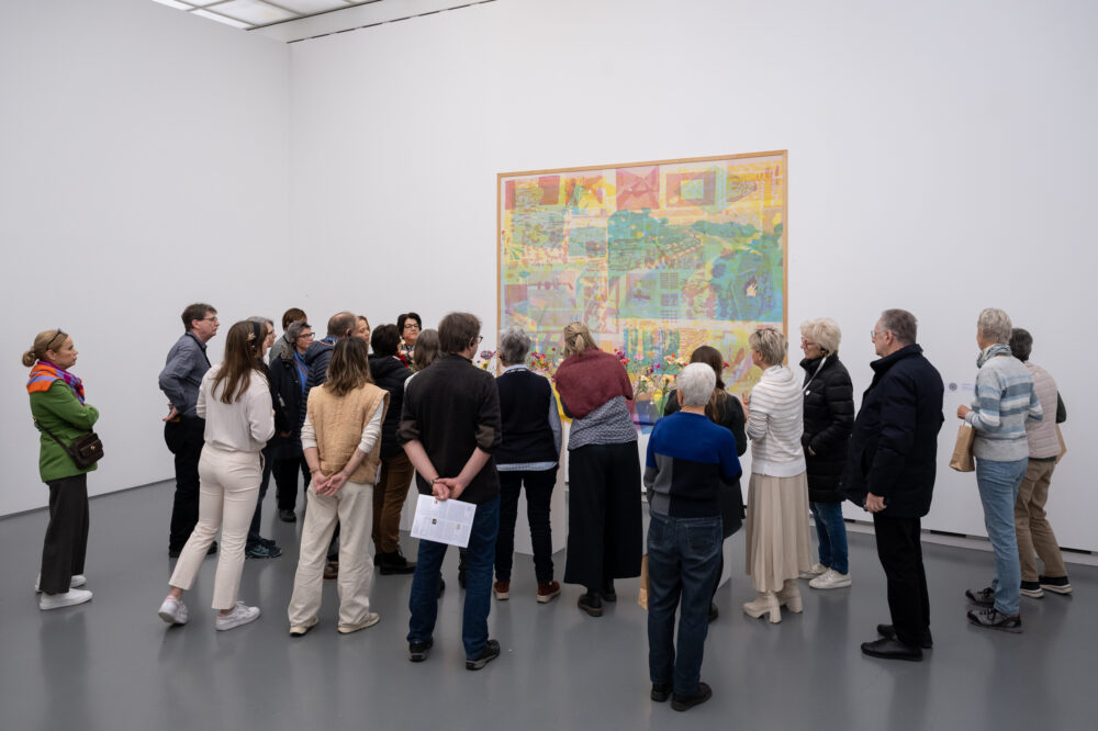 Foto von Personen, die vor einer Blumen für die Kunst Installation stehen