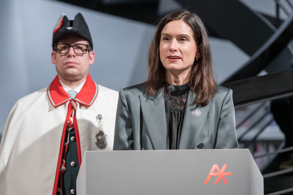 Foto von Maja Riniker, Nationalratspräsidentin, am Podium bei der Eröffnungsrede der Ausstellung