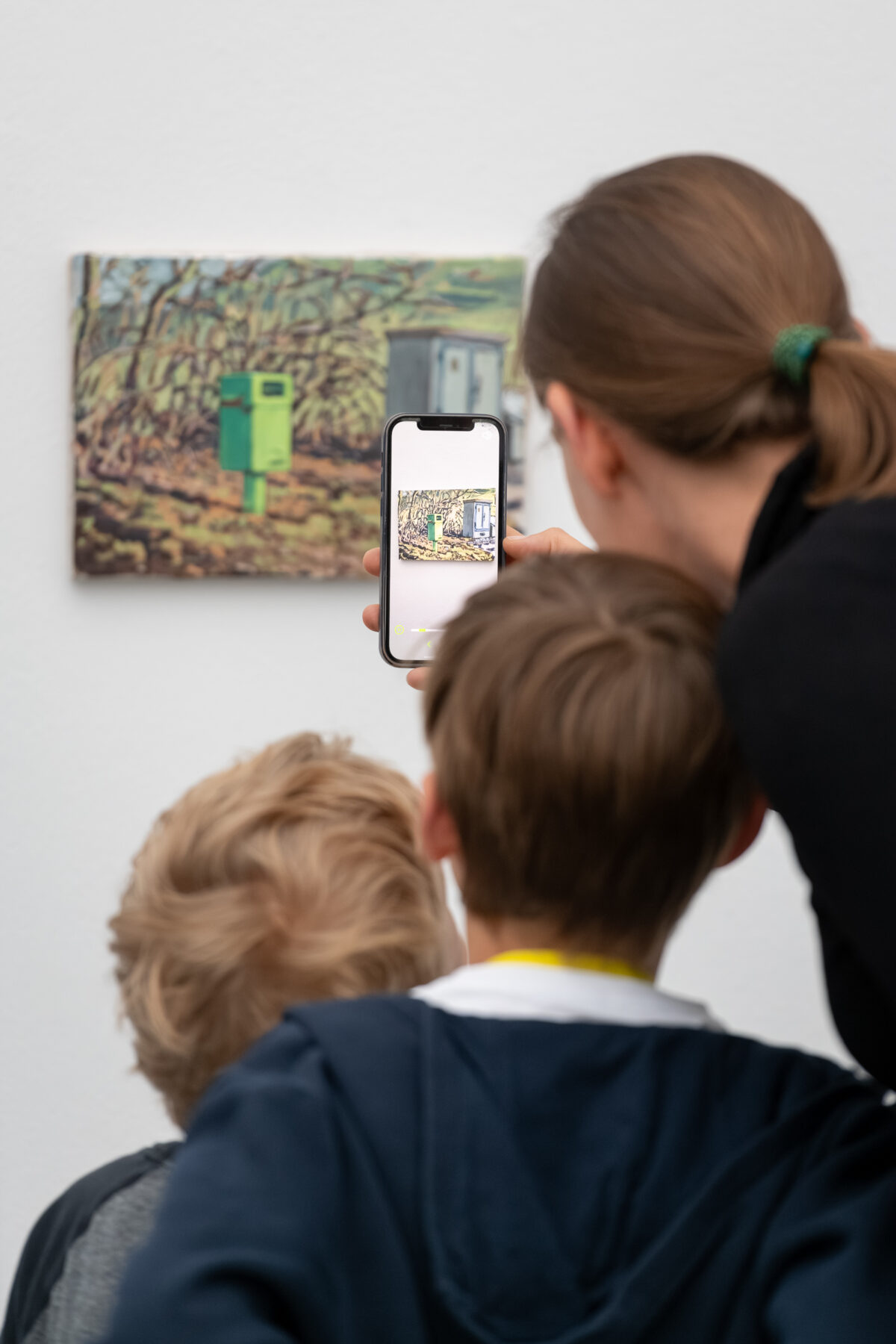 Kinder schauen mit einem Tablet in der Hand auf ein Sammlungswerk und erleben dank Augmented Reality eine animierte Version des Kunstwerkes