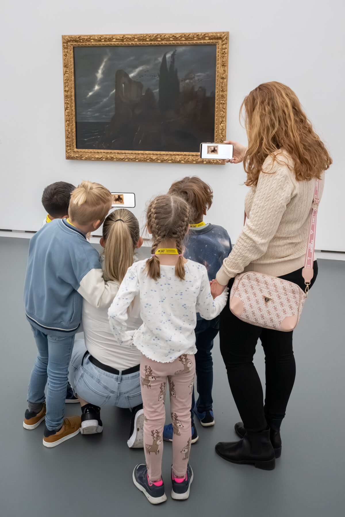 Kinder schauen mit einem Tablet in der Hand auf ein Sammlungswerk und erleben dank Augmented Reality eine animierte Version des Kunstwerkes