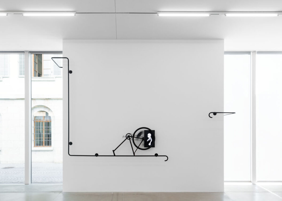 Ausstellungsansicht einer abstrakten Videoinstallation mit Stahlrohren und einem Bildschirm