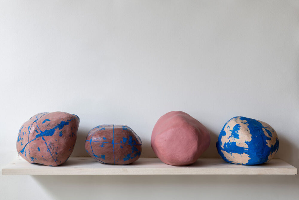 Ausstellungsansicht von vier bunt angemalten Steinen