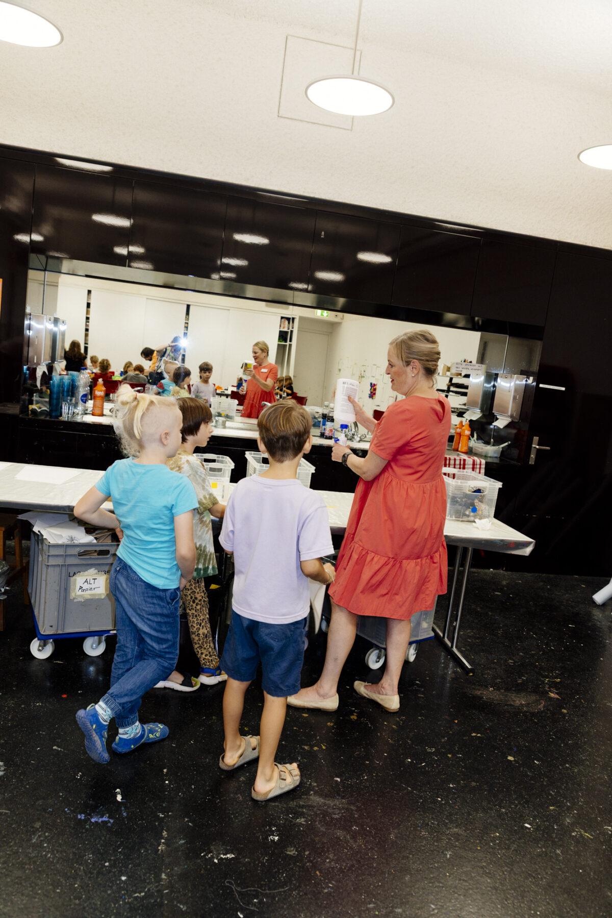 Kinder sind mit einer Vermittlerin am Basteln im Atelier