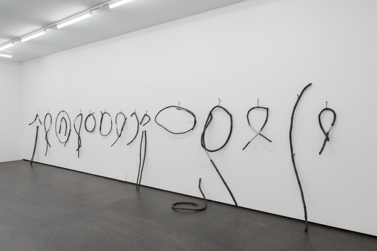 Eine Kunstwerkinstallation aus aufgehängten Fahrradschlauchartigen Linien an der Wand.