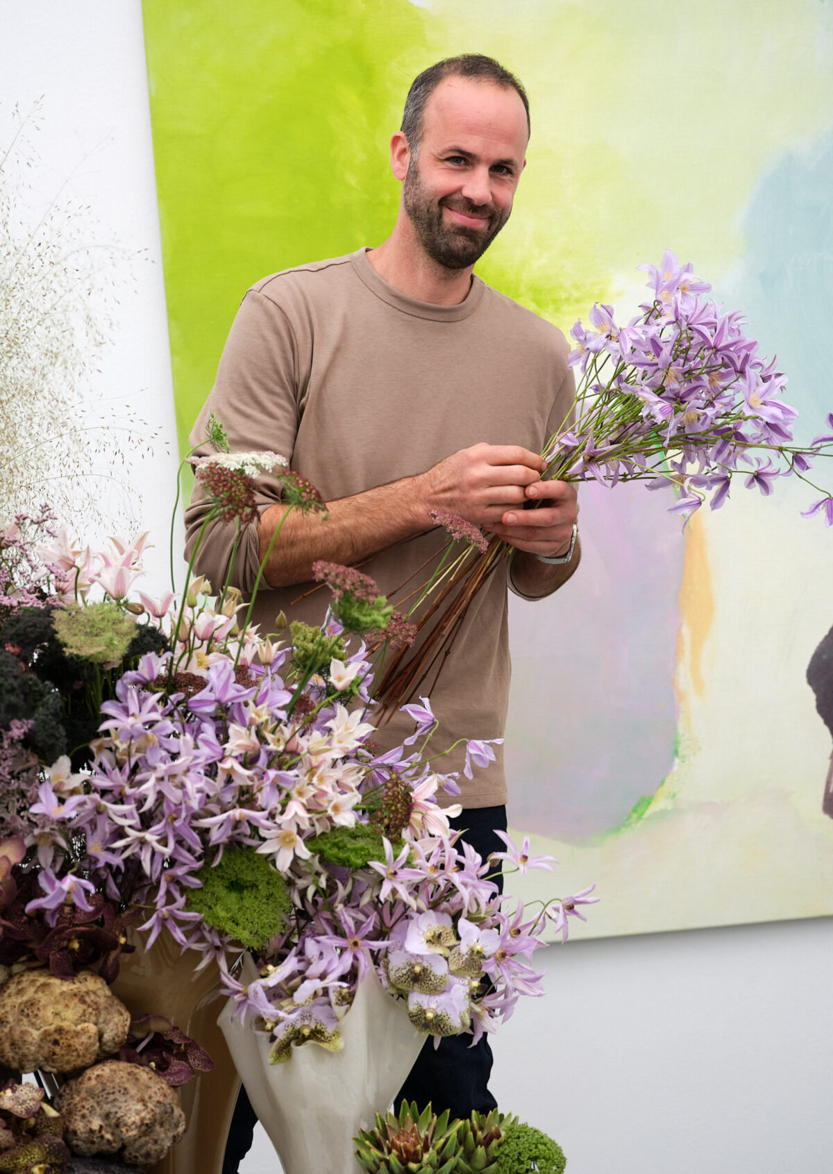 Portraitfoto von Rémy Jaggi mit einem Blumenstrauss in der Hand.