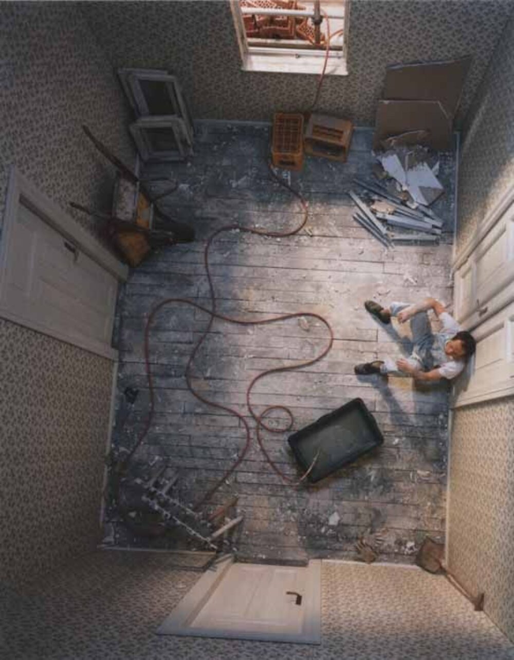 Foto eines Innenraums mit einem sitzenden Handwerker von oben aufgenommen.