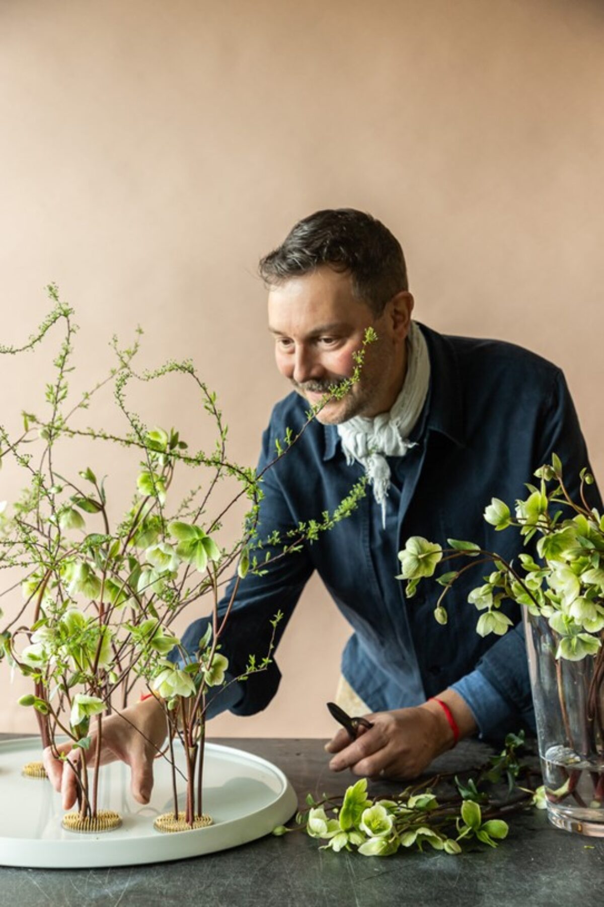 Foto von Nicolaus Peters, der gerade Blumen zusammensteckt.