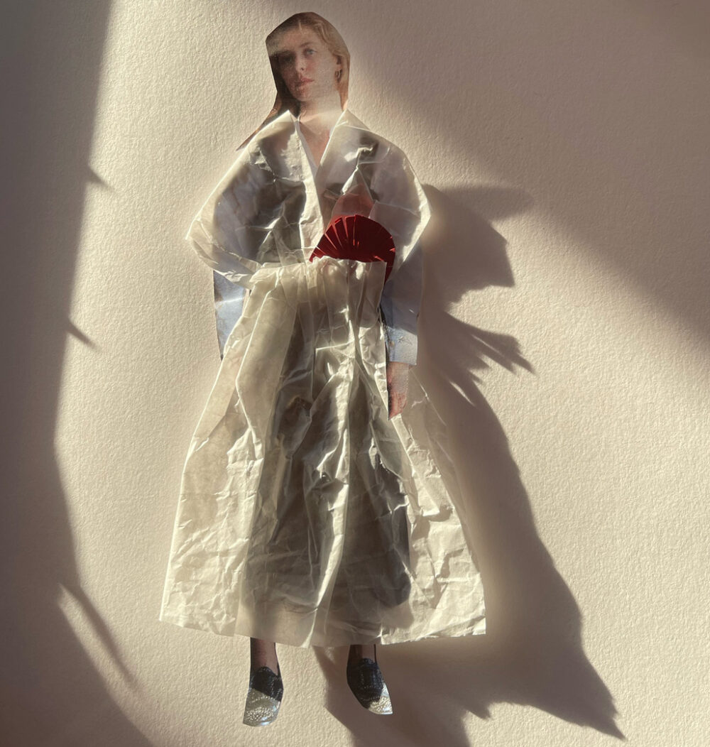 Foto einer Collage aus einer weiblichen, aus einem Magazin ausgeschnittenen Figur, die ein Kleid aus Japanpapier trägt.