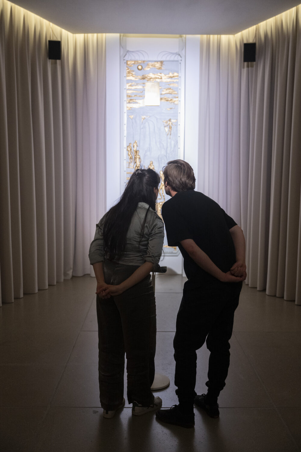 Zwei Besuchende sprechen in ein Mikrofon der Installation der Kunstschaffenden Herndon & Dryhurst.
